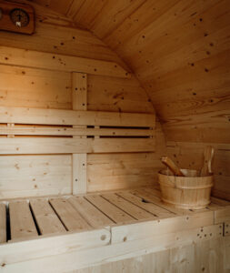 Espace détente avec un sauna tonneau scandinave en extérieur